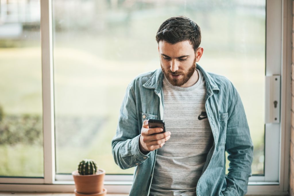 スマホを見ている男性の画像